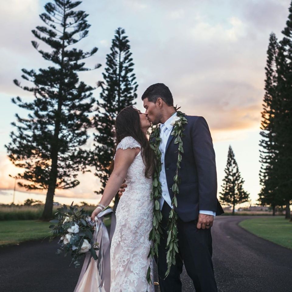 Сouple wearing a white gown and a black suit on the road